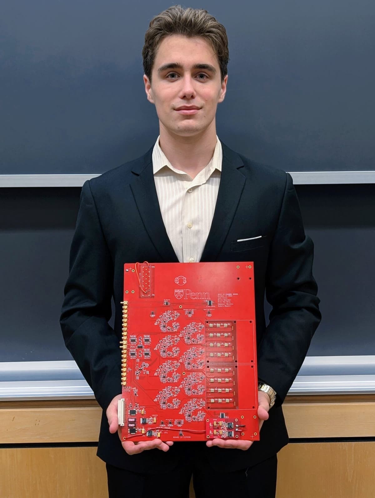 Max Malakhovets holding a printed circuit board